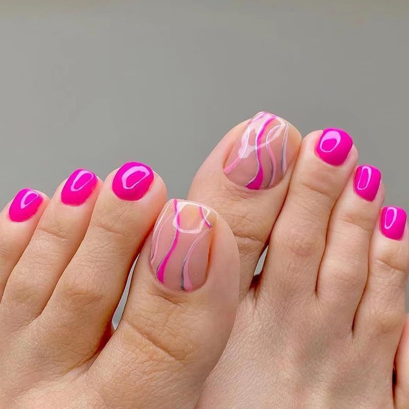 Close-up of a person's feet with hot pink and wavy patterned press-on toenails.