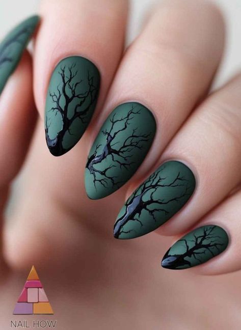 Close-up of manicured hand with all five fingernails painted matte dark green and adorned with black, leafless tree designs.