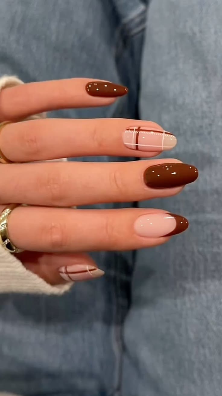 A hand displays coffin-shaped nails with alternating designs in brown and nude.