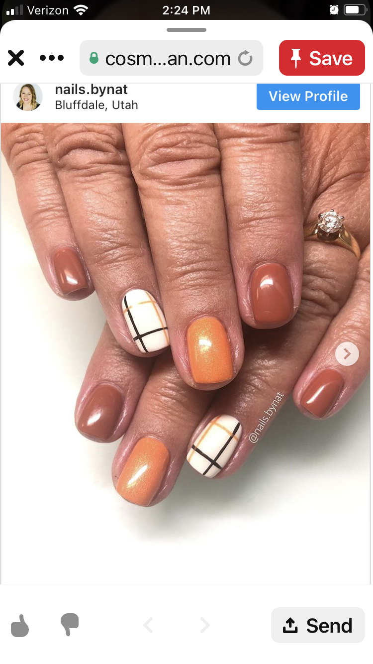 Close-up of a person's hands with manicured nails. Some nails are solid orange or brown, while others have a plaid design.