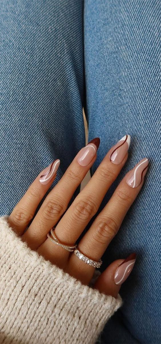Pointed coffin nails with abstract brown and white swirls over a nude base.