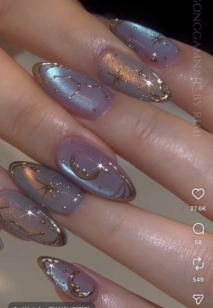 Close-up of manicured hands with almond-shaped nails featuring celestial designs in iridescent lavender and gold.