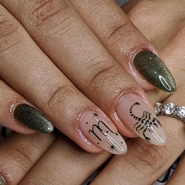 Close-up of a hand with Scorpio symbol, scorpion, and glitter design manicured nails on an elegant ringed finger.