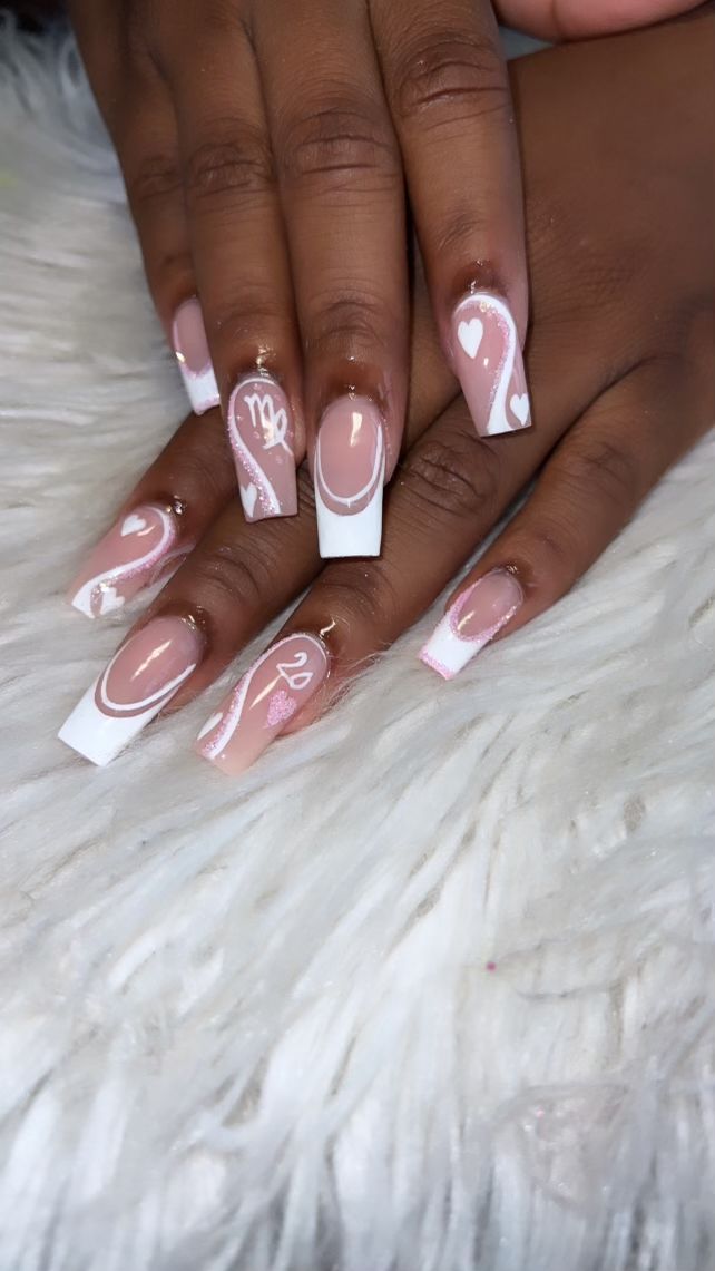 Manicured hands with square-tipped nails feature a neutral pink base, white French tips, white swirl designs, and small…