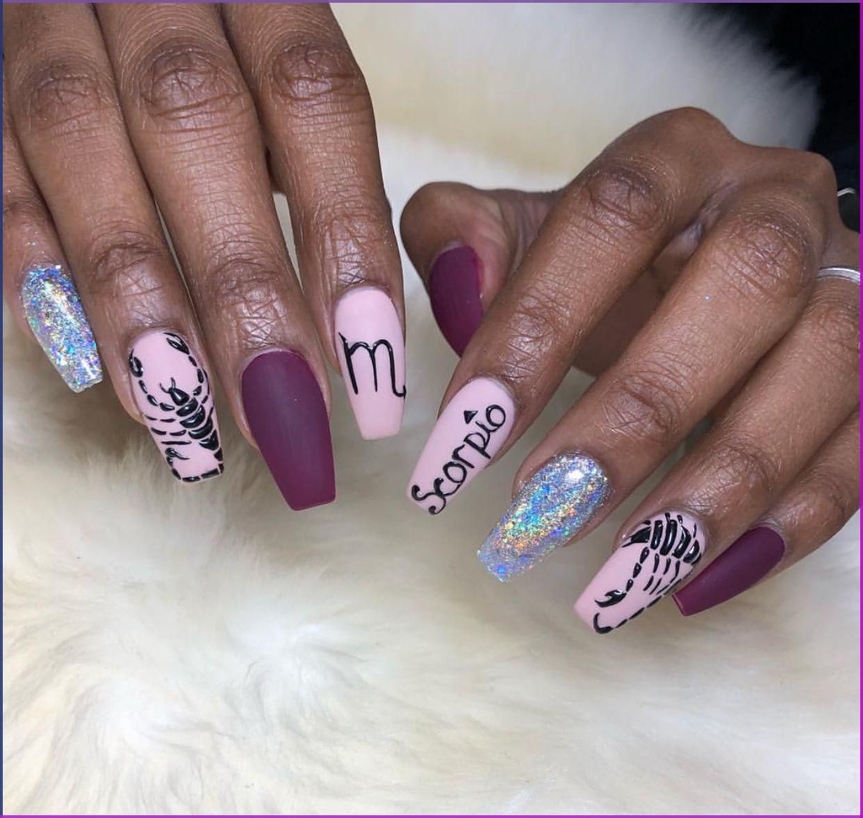 Close-up of a person's hands with glitter, matte plum, and pale pink coffin-shaped nails.