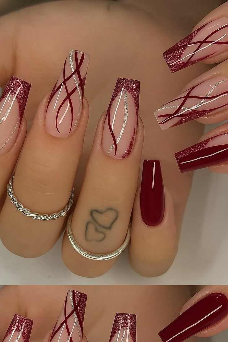 Several coffin-shaped fingernails, some with solid burgundy polish, others with burgundy glitter tips, and intricate…