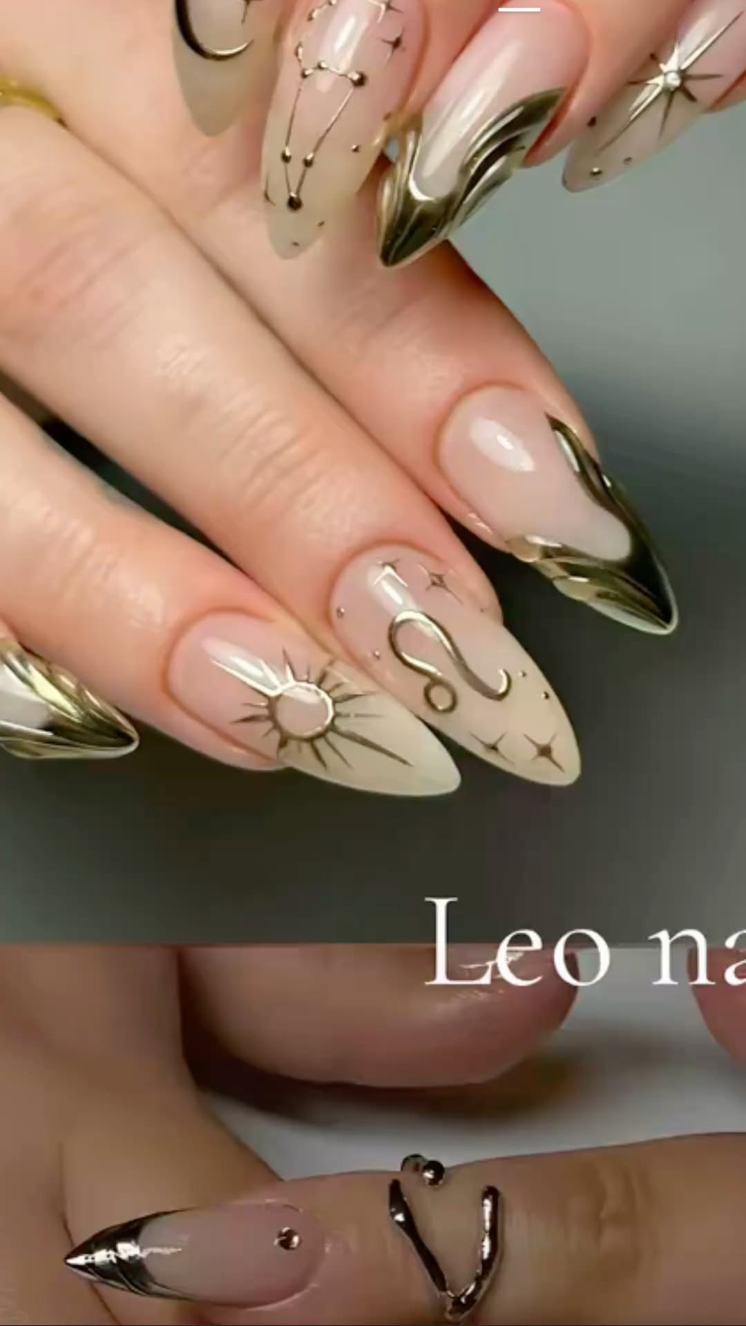 Close-up of a hand with long, pointed nails. Each nail features a different metallic gold design, including constellations…