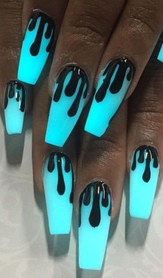 Long, coffin-shaped nails with a glowing blue base and black dripping design on top.