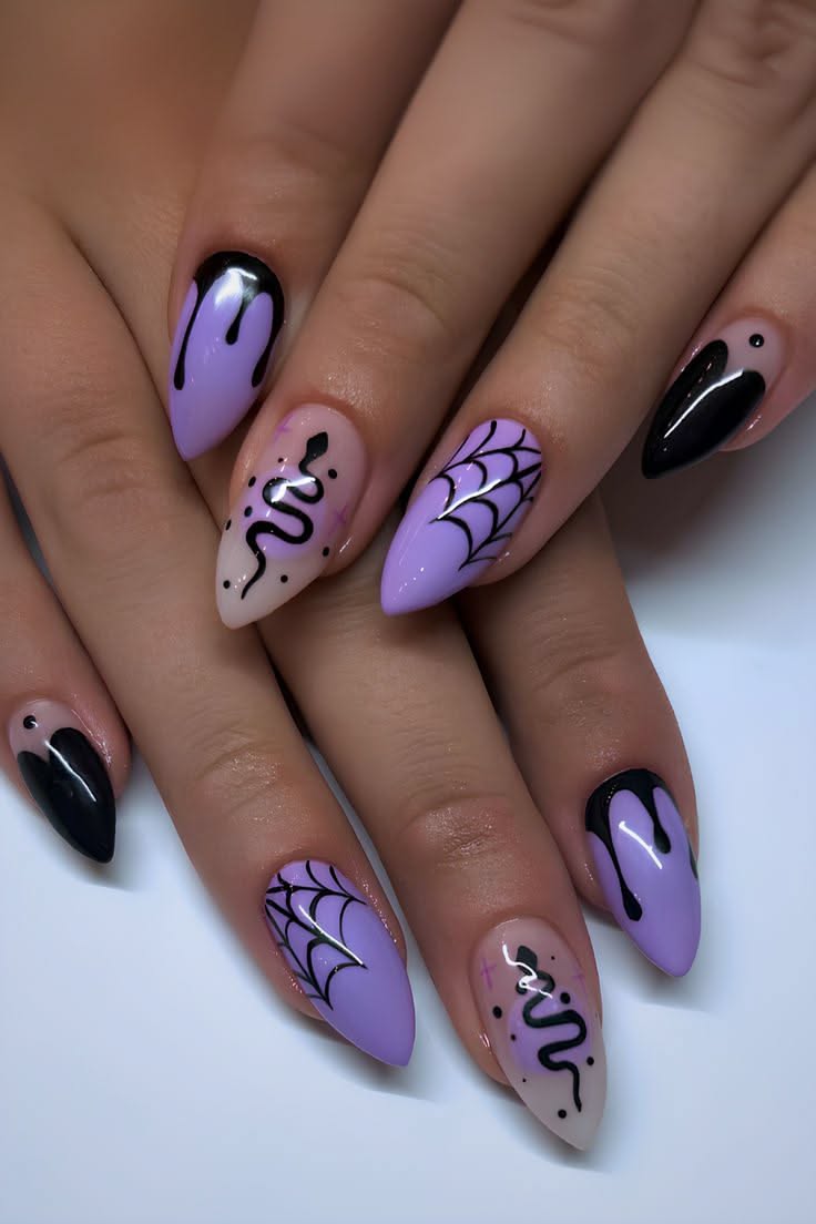Close-up of a person's hands with Halloween-themed nail art. Nails feature black drips, spiderwebs, and a snake design.