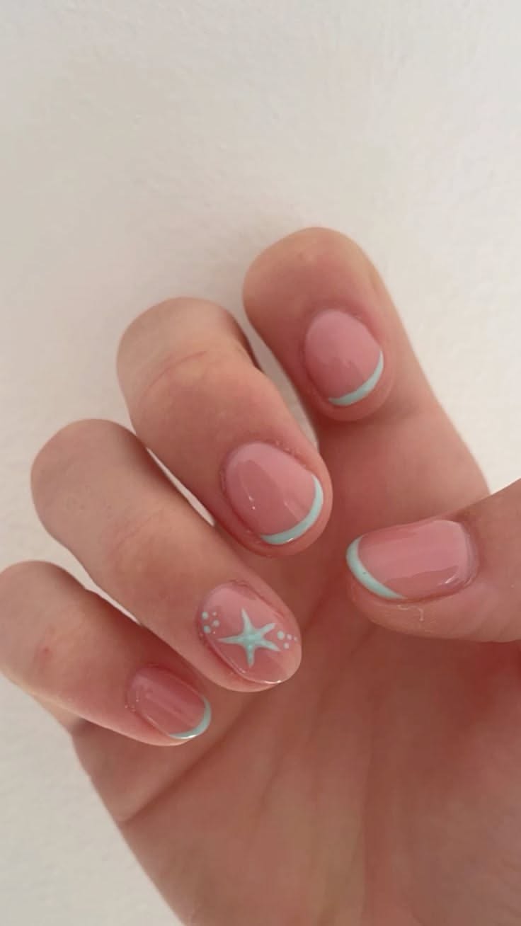 Close-up of a person's hand with short, light pink nails, each featuring a light blue French tip.