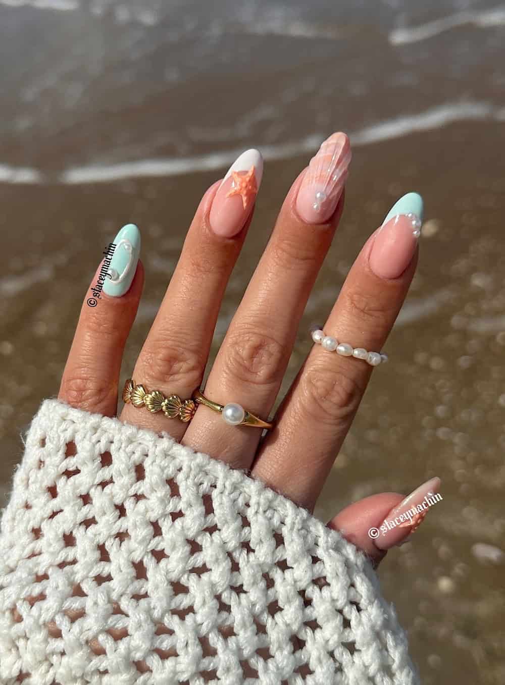 Hand with long almond nails in bright summer colors and graphic nail art
