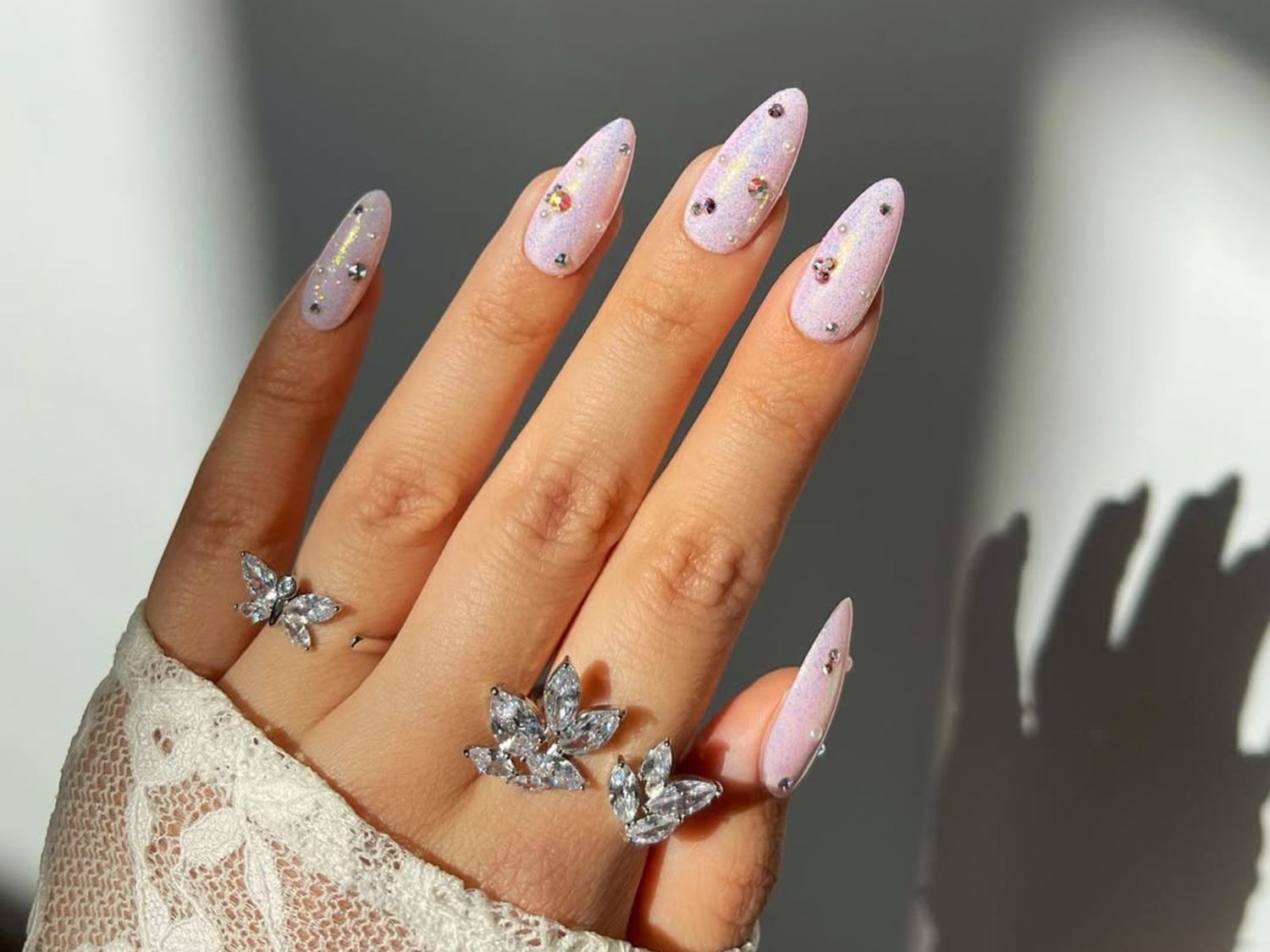 Hand with elegant light-colored summer manicure and subtle nail art