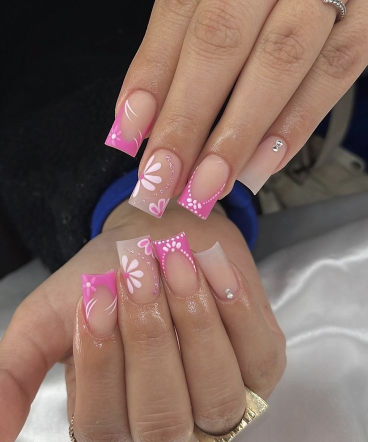 Short square nails painted pink with floral nail art