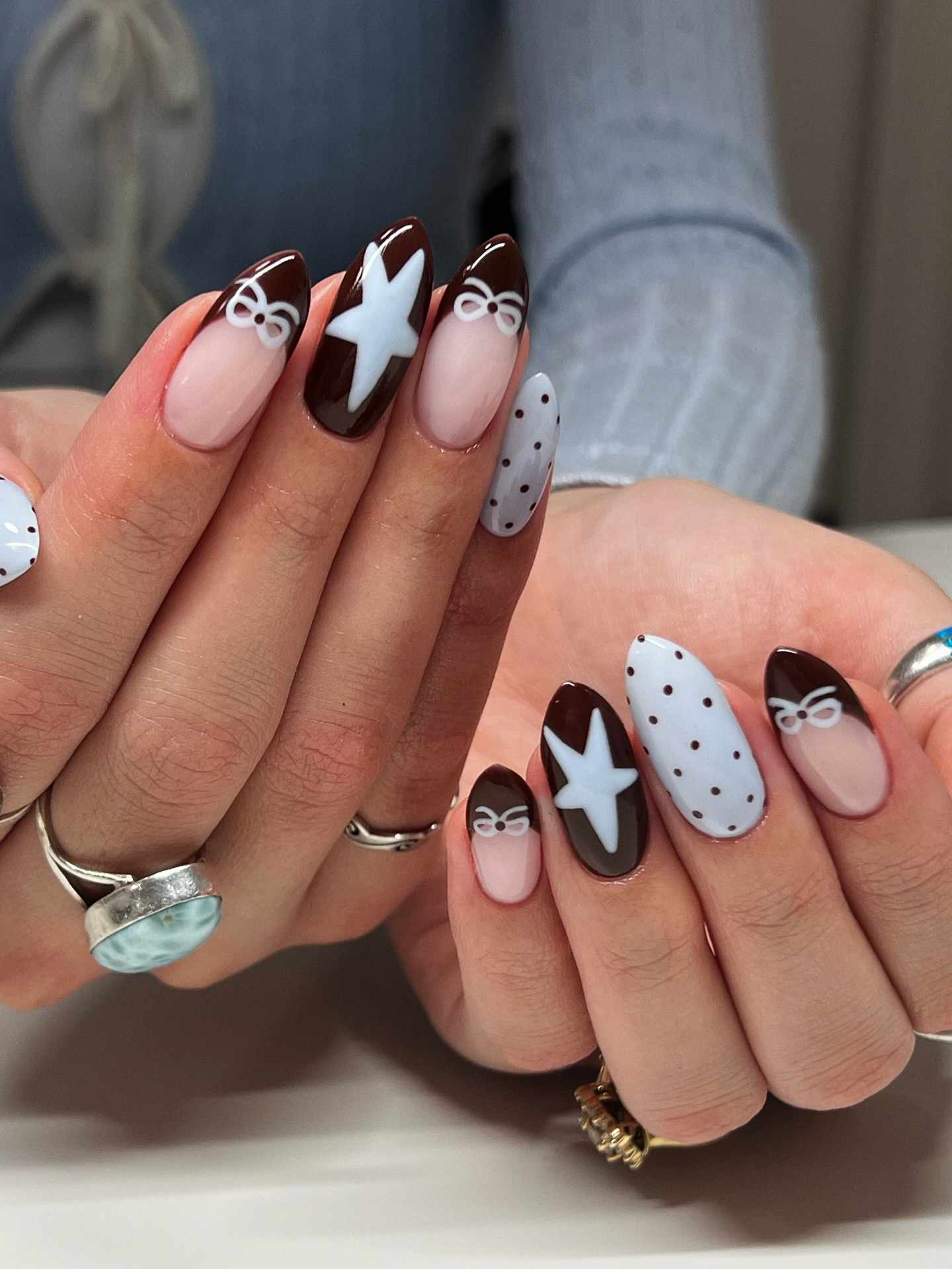 Long almond nails with brown and nude swirl nail art.
