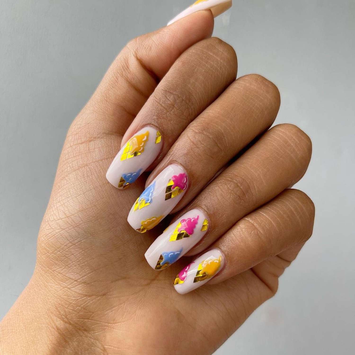 Square manicure with colorful summer nail art on a hand
